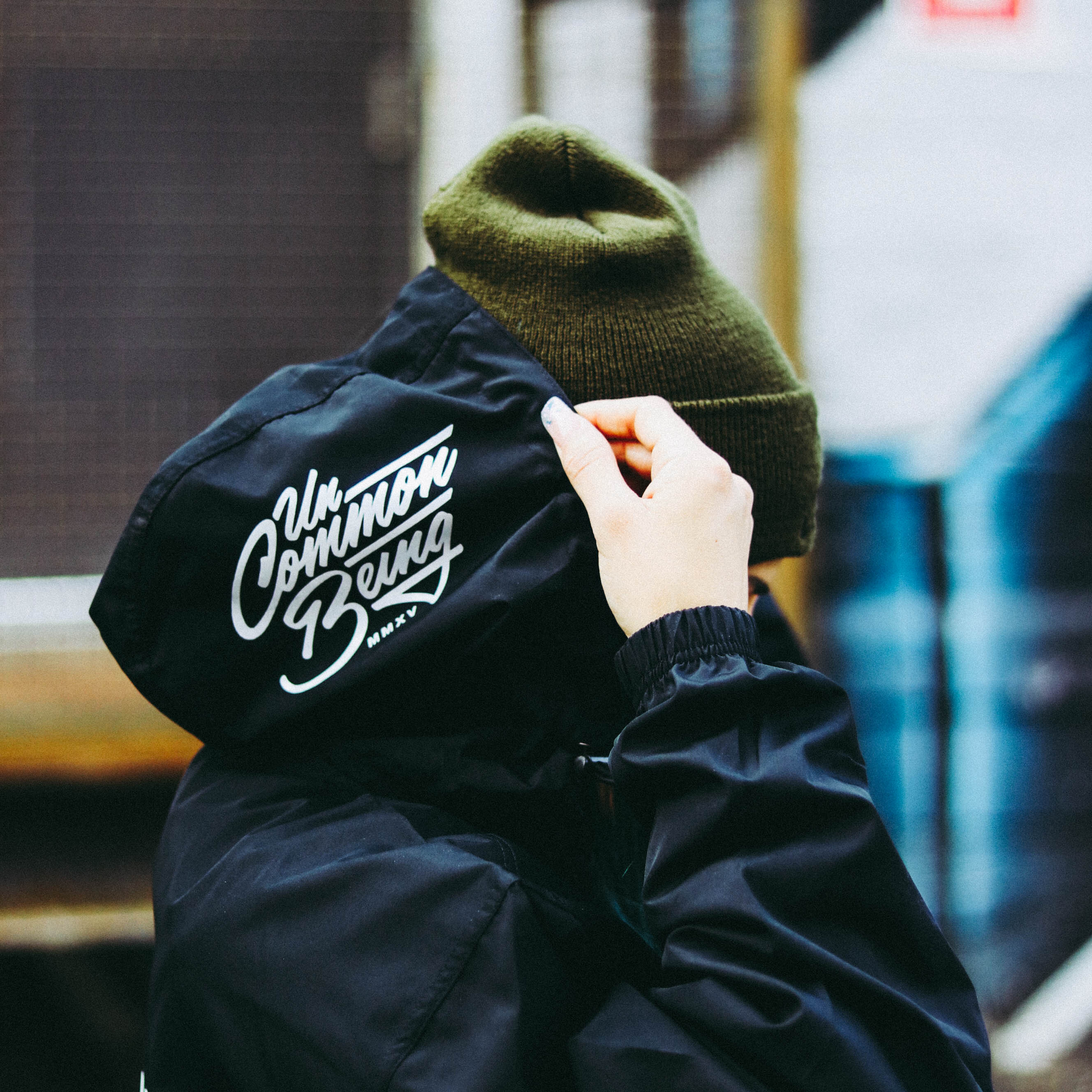 Streetwear model in an Uncommon Being jacket and knit cap